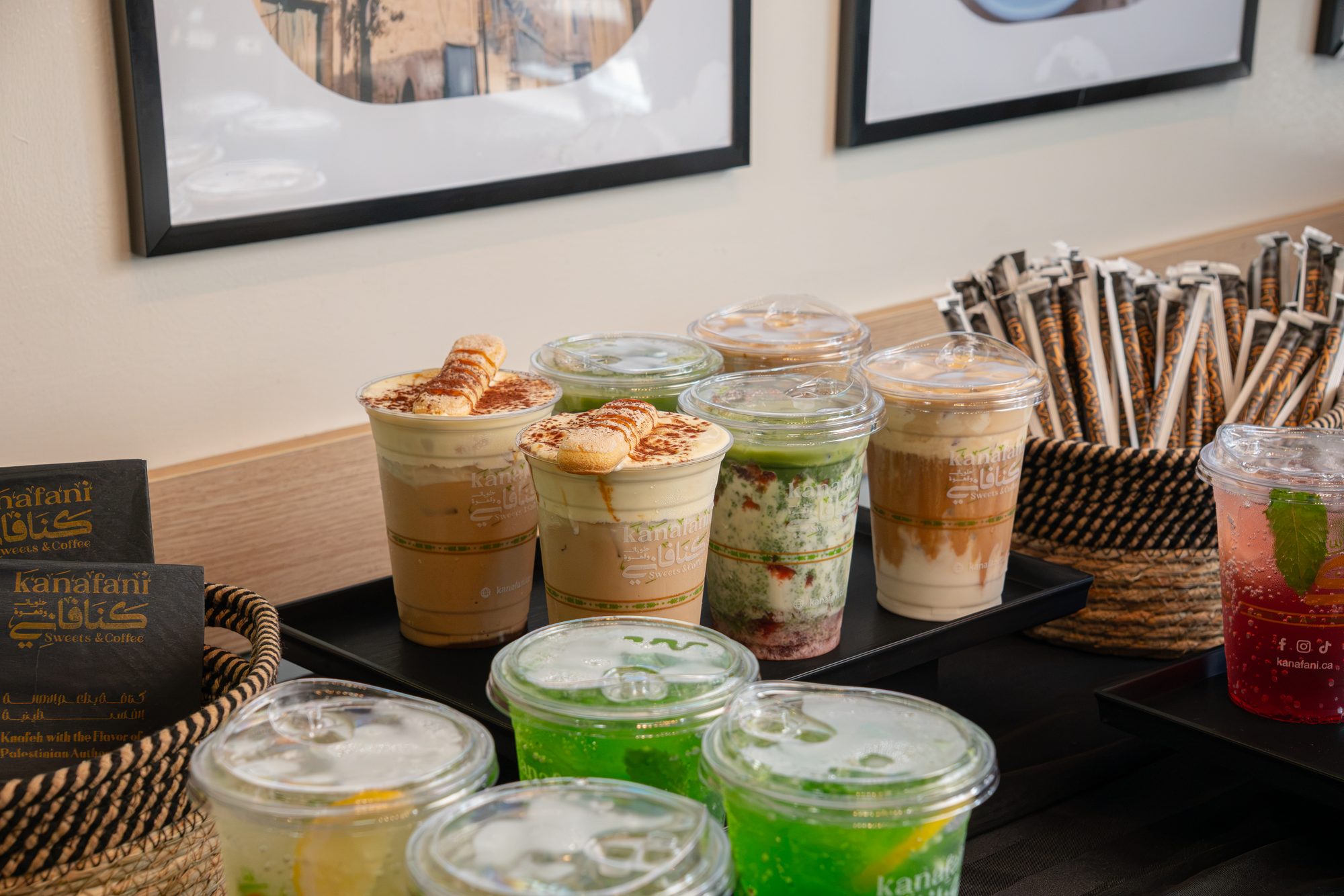 A row of iced coffees and layered dessert cups on the counter